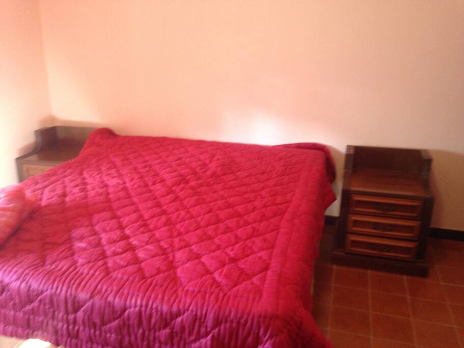 ampio letto matrimoniale con 2 comodini