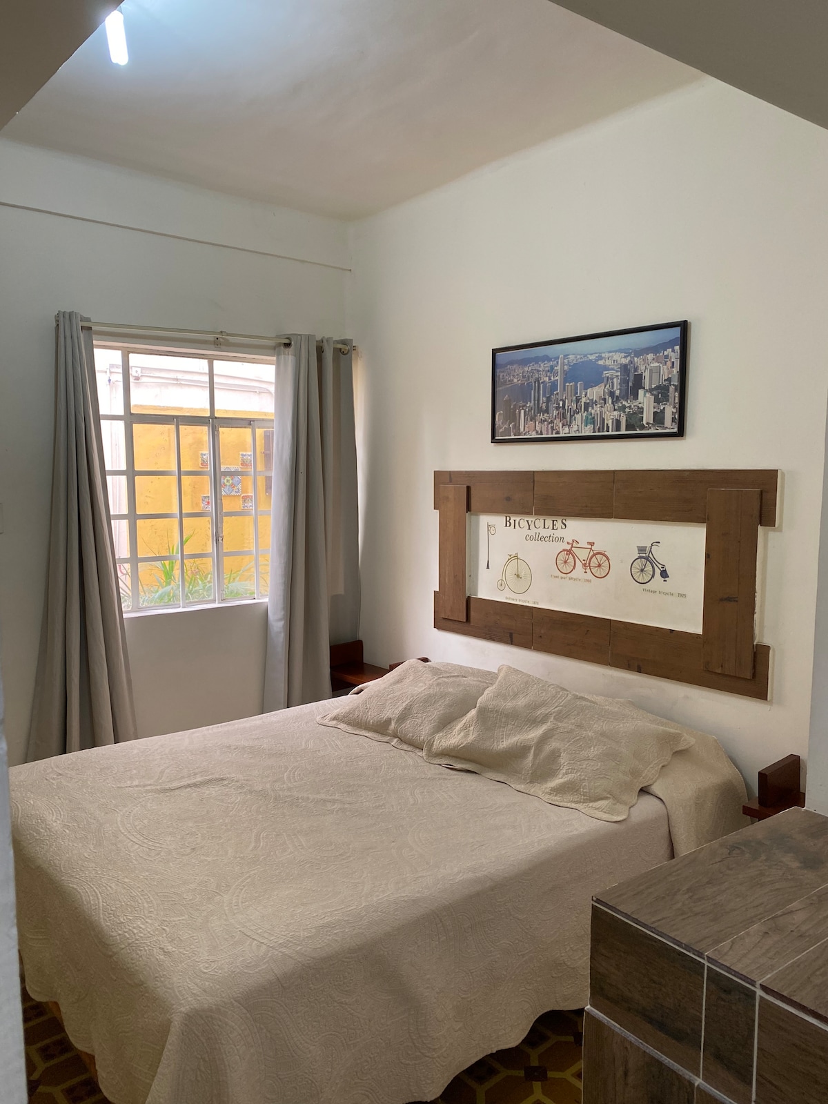 ห้องนอนพร้อมเตียงควีนไซส์หน้าต่างทางเดินและตู้เสื้อผ้า 