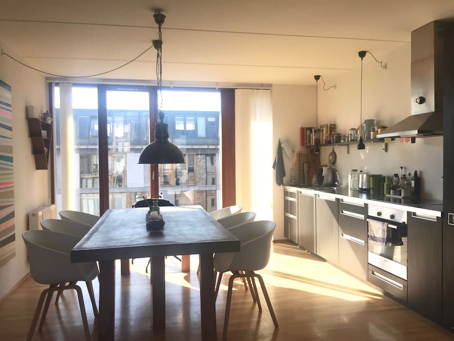 Bright dining area with an open kitchen and a dining table for 8 people.