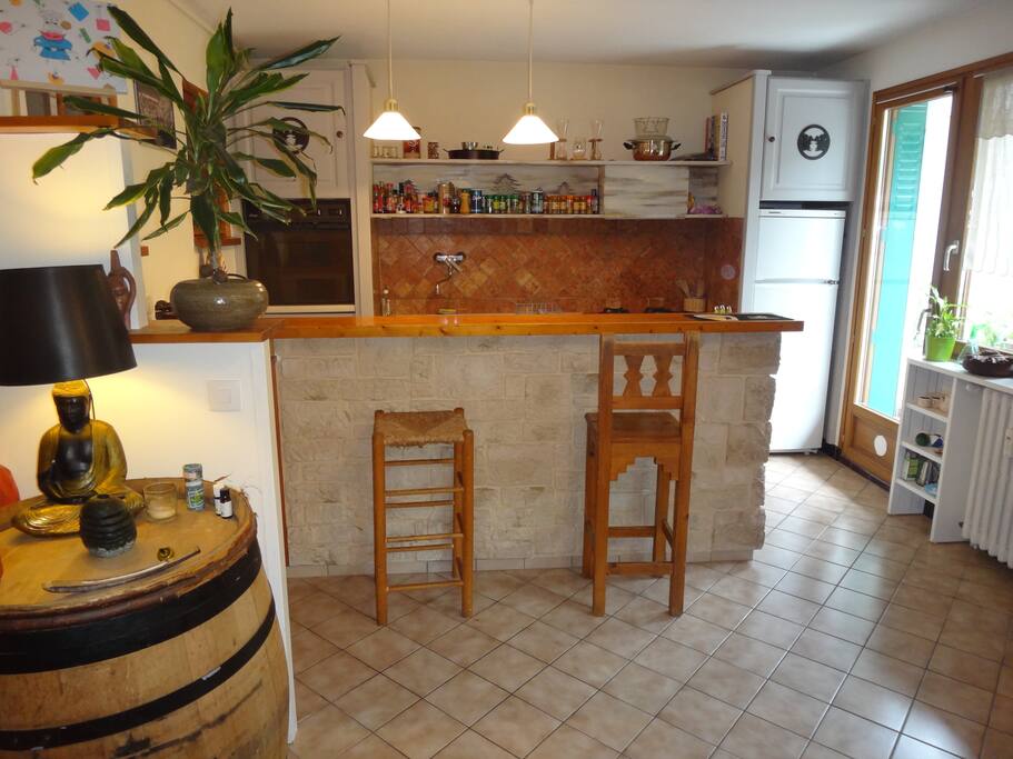 Vue sur la cuisine, porte fenêtre donnant sur la terrasse à droite