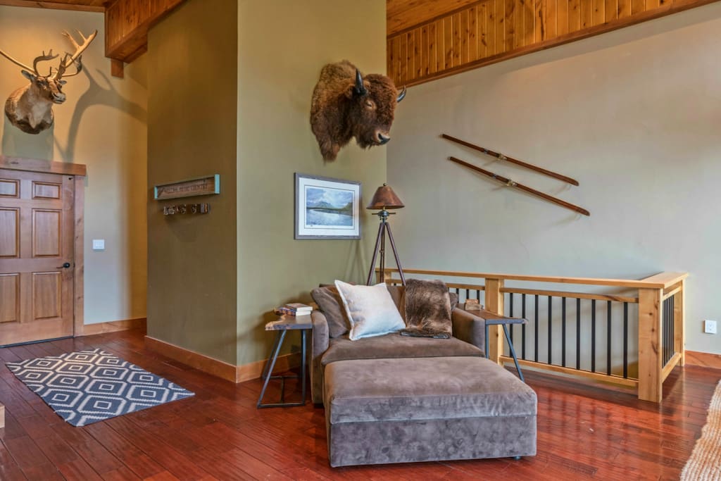 Comfy reading loveseat under bison & caribou mounts and Peter Corbin artwork