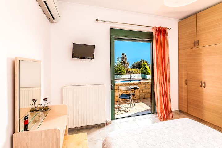 Ground Floor: Bedroom 2 with queen bed and private balcony.