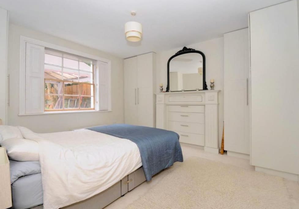 Master bedroom with king-sized bed, overlooking the garden