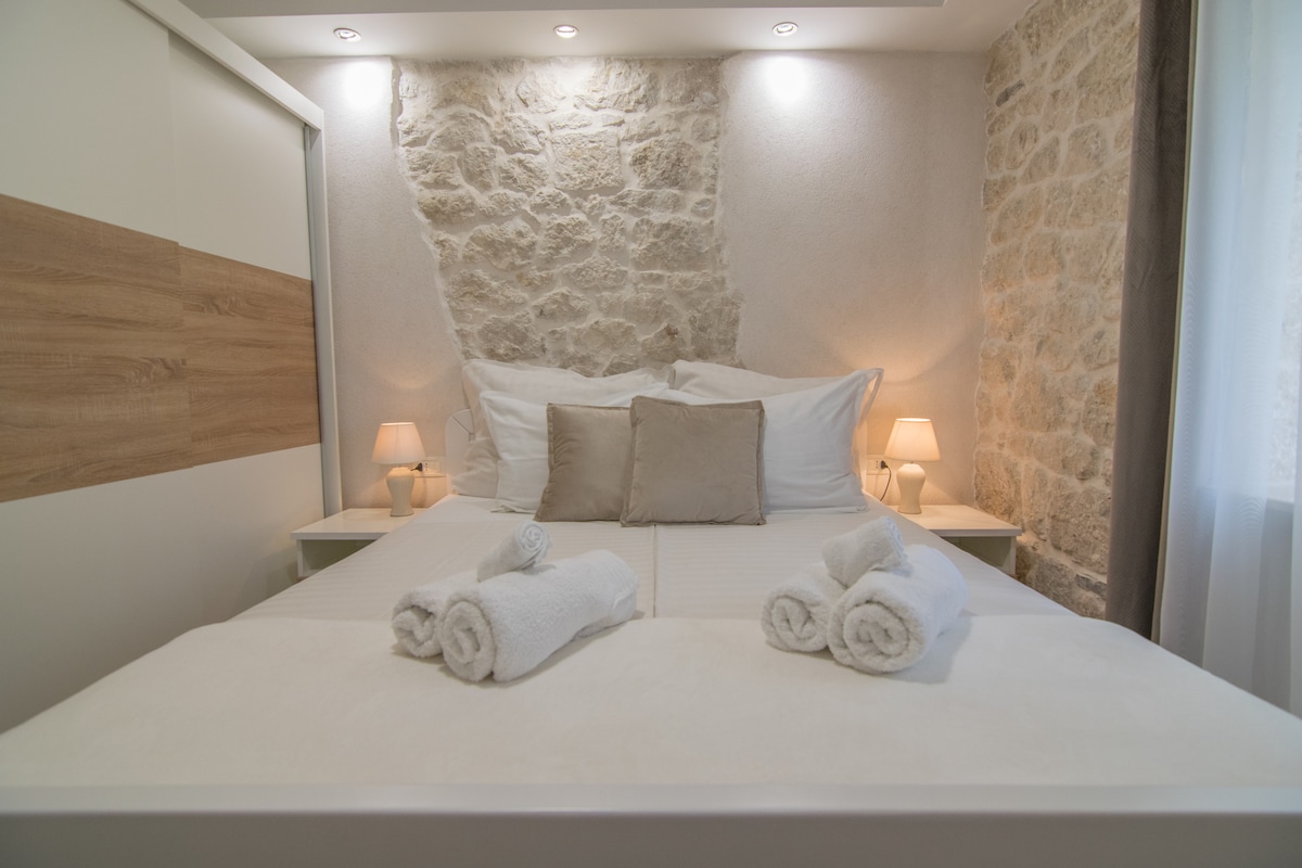 ห้องนอนที่อบอุ่นพร้อมการตกแต่งที่ดีทีวีและพัดลมเพดาน