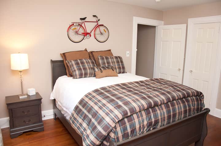 Rear Bedroom 2 - Features a queen size bed, located upstairs, with closet space. Nightstand with an alarm clock and power outlets nearby to charge electronics.