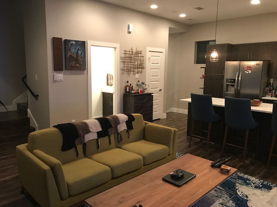 Kitchen and living room open space with partial view of downstairs half bath.