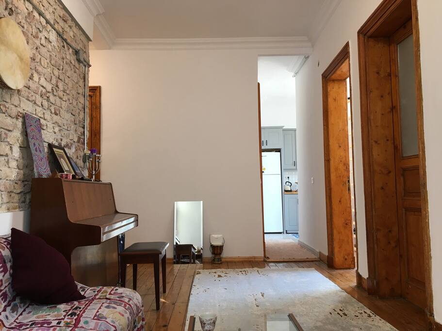 Living room to the kitchen, tall ceilings, wood floors.