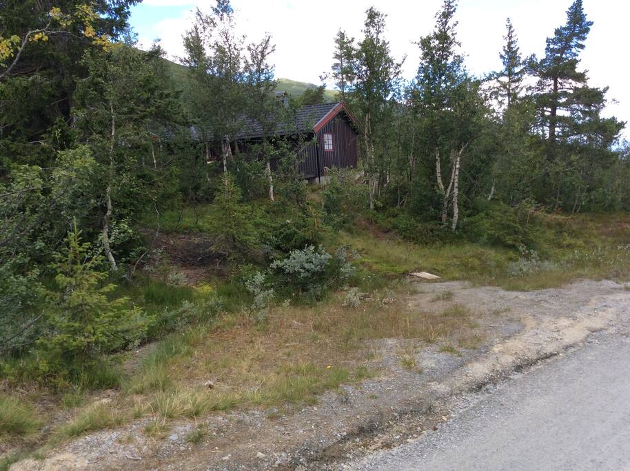 hytta sett fra veien, med parkeringsmulighet rett foran hytta i kanten av veien. Det er også parkering med plass til ca 4 bilder 10meter unna.
