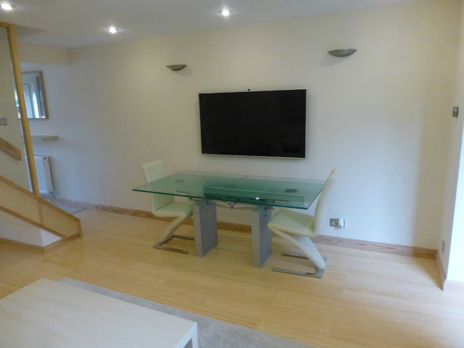 Living Room with Designer Dining Table and large smart TV.