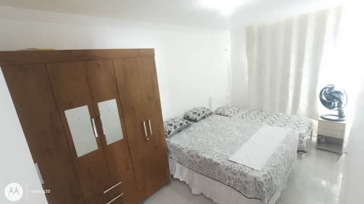 Suite con cama doble 1 individual y baño con ventilador frente al mar.