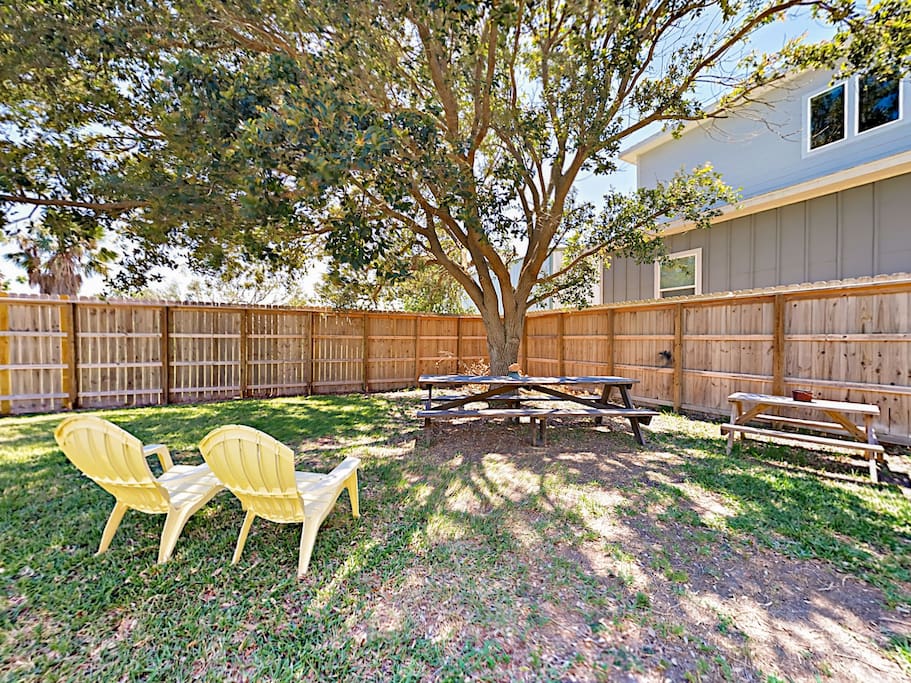 Relax in the shaded fenced yard, equipped with 2 picnic tables and armchairs.