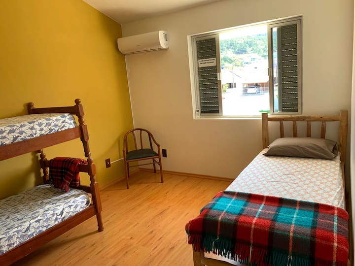 חדר עם שלוש מיטות יחיד ונוף להרים.