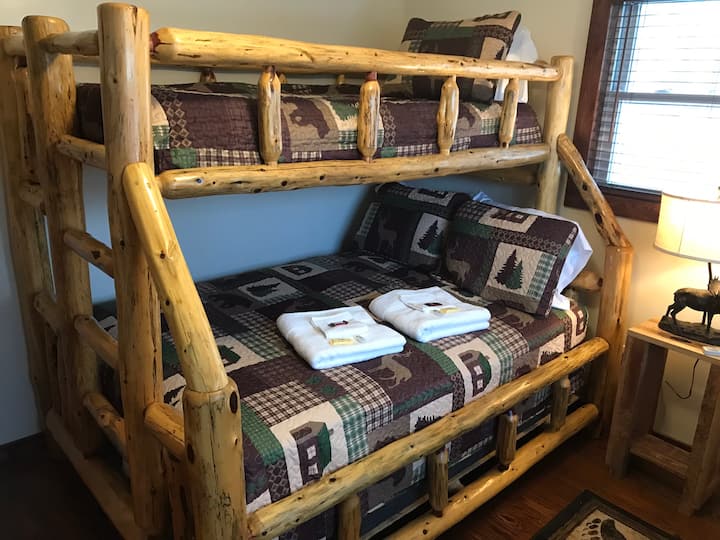 Second bedroom with solid log double bed with twin on top.