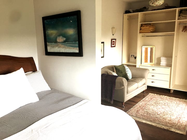 La chambre 1 dispose d'un coin salon donnant sur le jardin et d'une salle de bains privative partagée avec la chambre 2