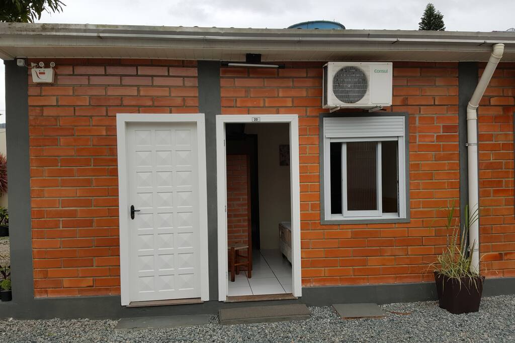 Entrada da suíte com ar condicionado, cozinha completa, banheiro e vaga de garagem coberta