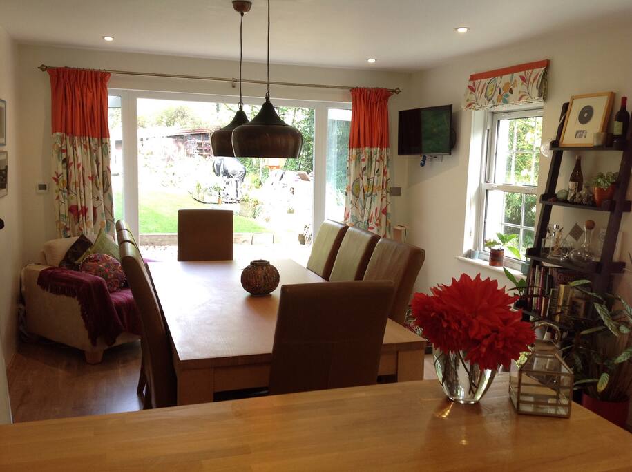 Kitchen dining area looking onto flower garden and woodland.
