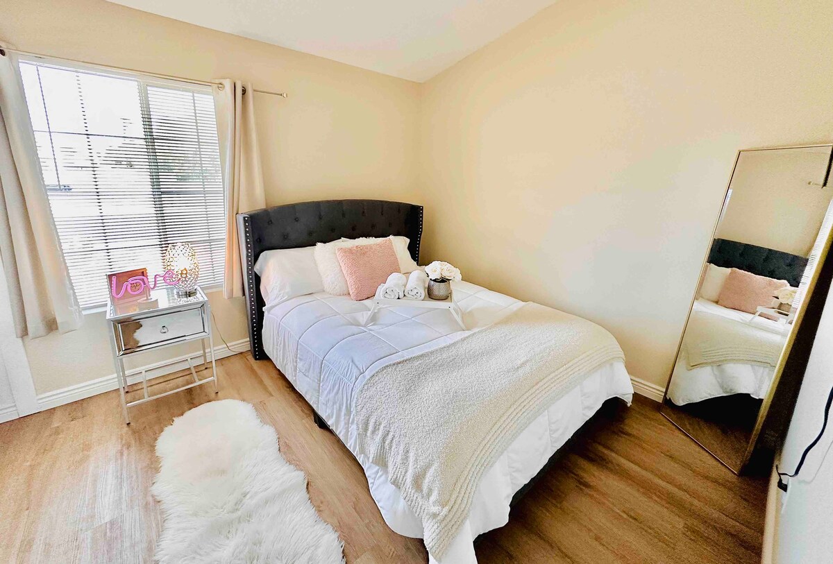 ห้องนอนที่สองพร้อมเตียงควีนไซส์เตียงกลางคืนขาตั้งกระจกและสมาร์ททีวี