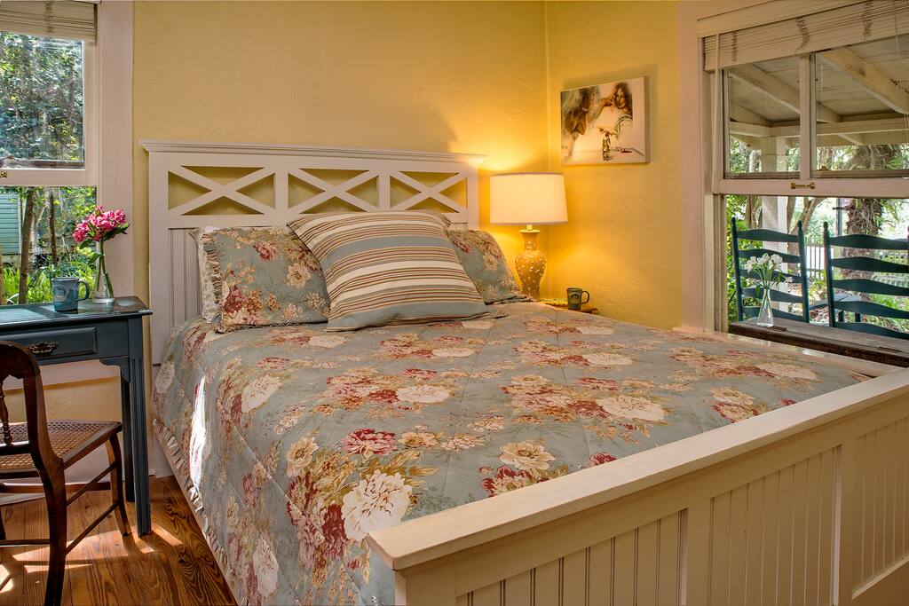 Bedroom with queen bed, dresser and desk.