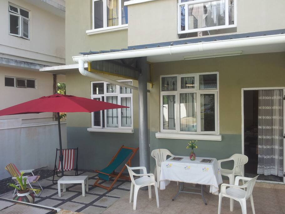Terrace with chairs and tables and large umbrella for morning breakfast and evening drinks/apero.