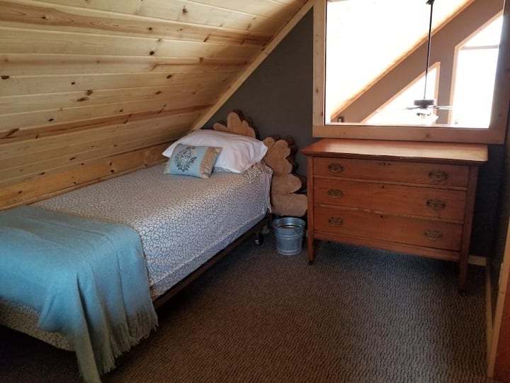 מיטה זוגית ושידה בחדר השינה המזרחי.  יש גם מיטת קווין סייז בחדר הזה.