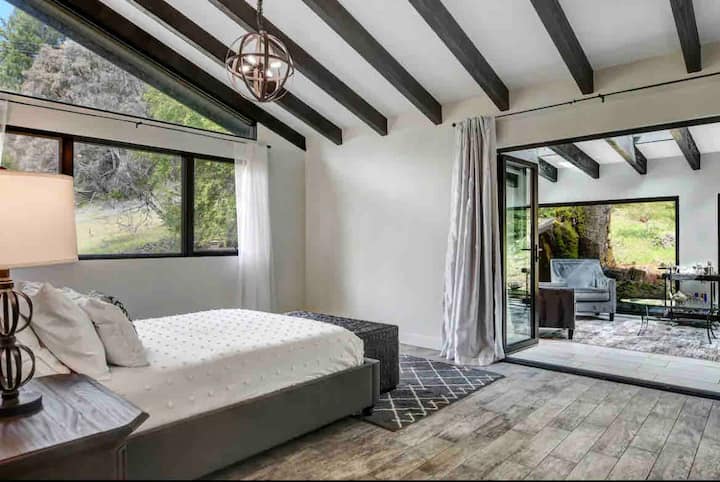 1er. Découvrez la retraite ultime dans notre chambre 1, la chambre des maîtres avec douche. Des portes coulissantes ouvertes donnent sur la véranda avant, mêlant de manière transparente le confort intérieur et la sérénité extérieure.