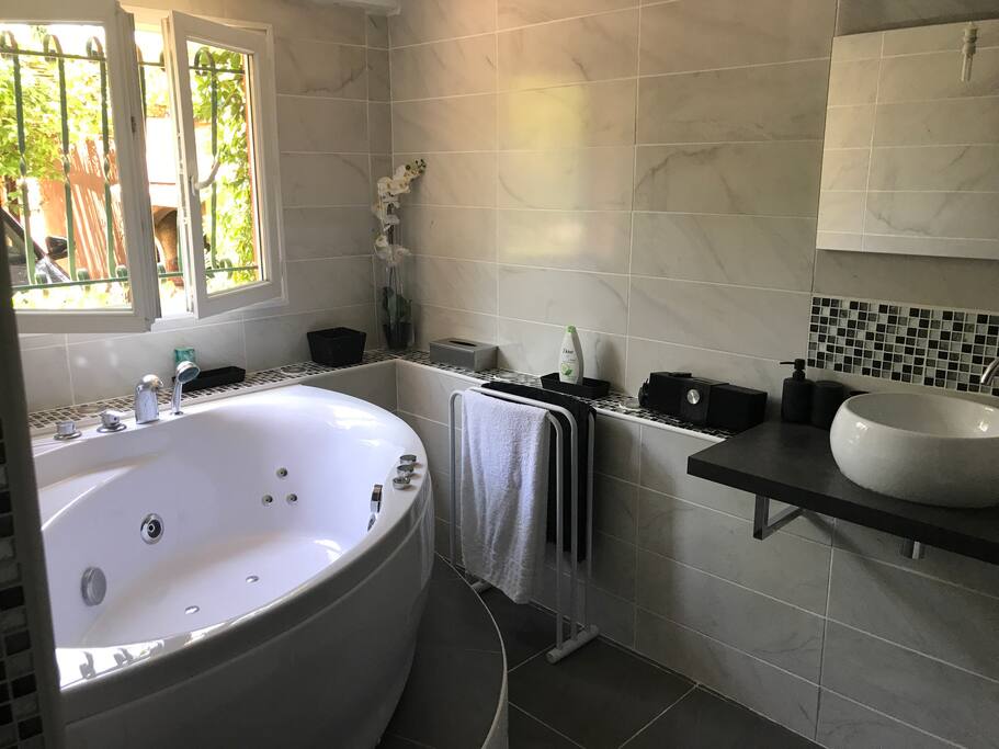 La salle de bain privative avec wc et baignoire jacuzzi.