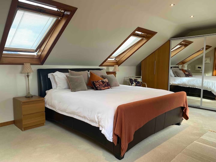 Loft conversion with open plan large bedroom with superking size bed and 4 windows. With amazing views of hills and for miles. 