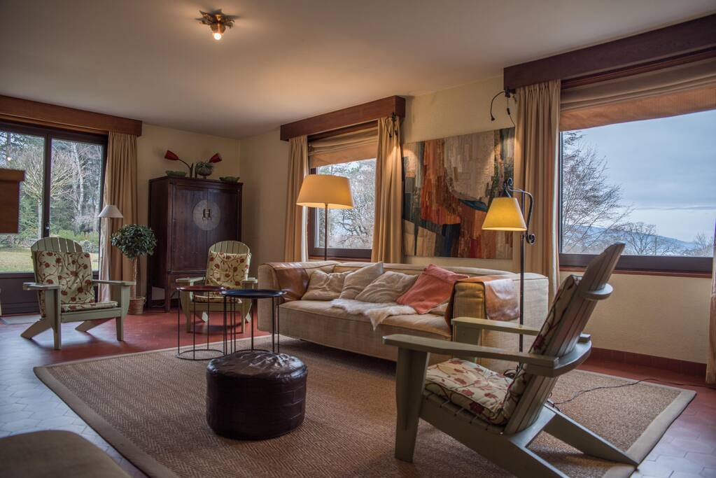 Salon traversant avec poele a bois et vue lac