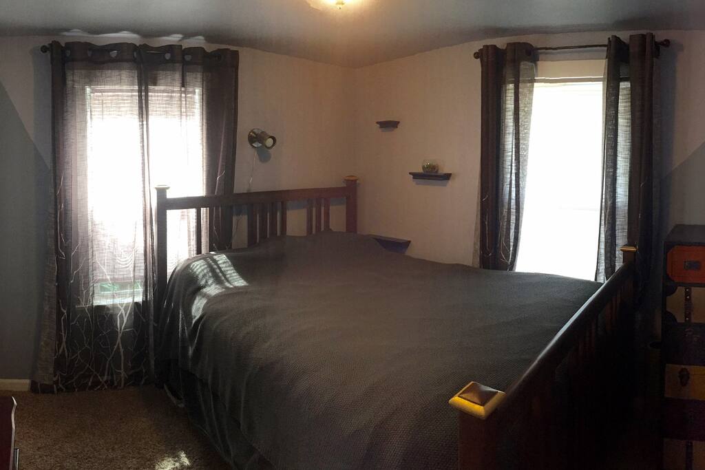 Private room with queen size bed and bathroom across the ahll