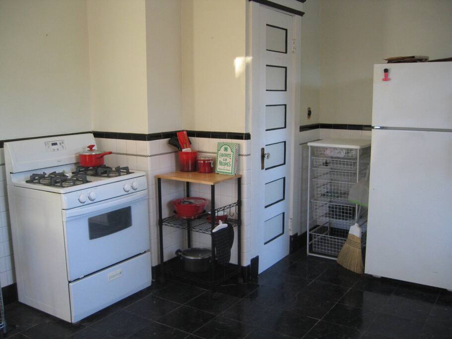 Other side of kitchen, stove, fridge, closet pantry