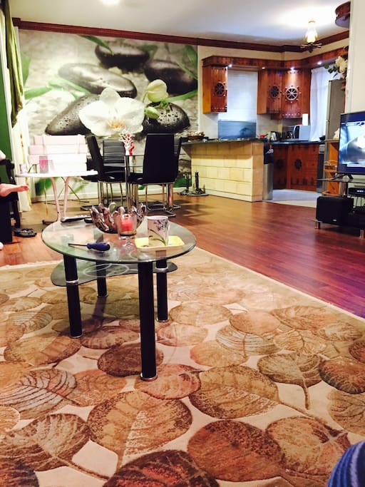 Living room view along with open dining area seating 8 people and an open kitchen.