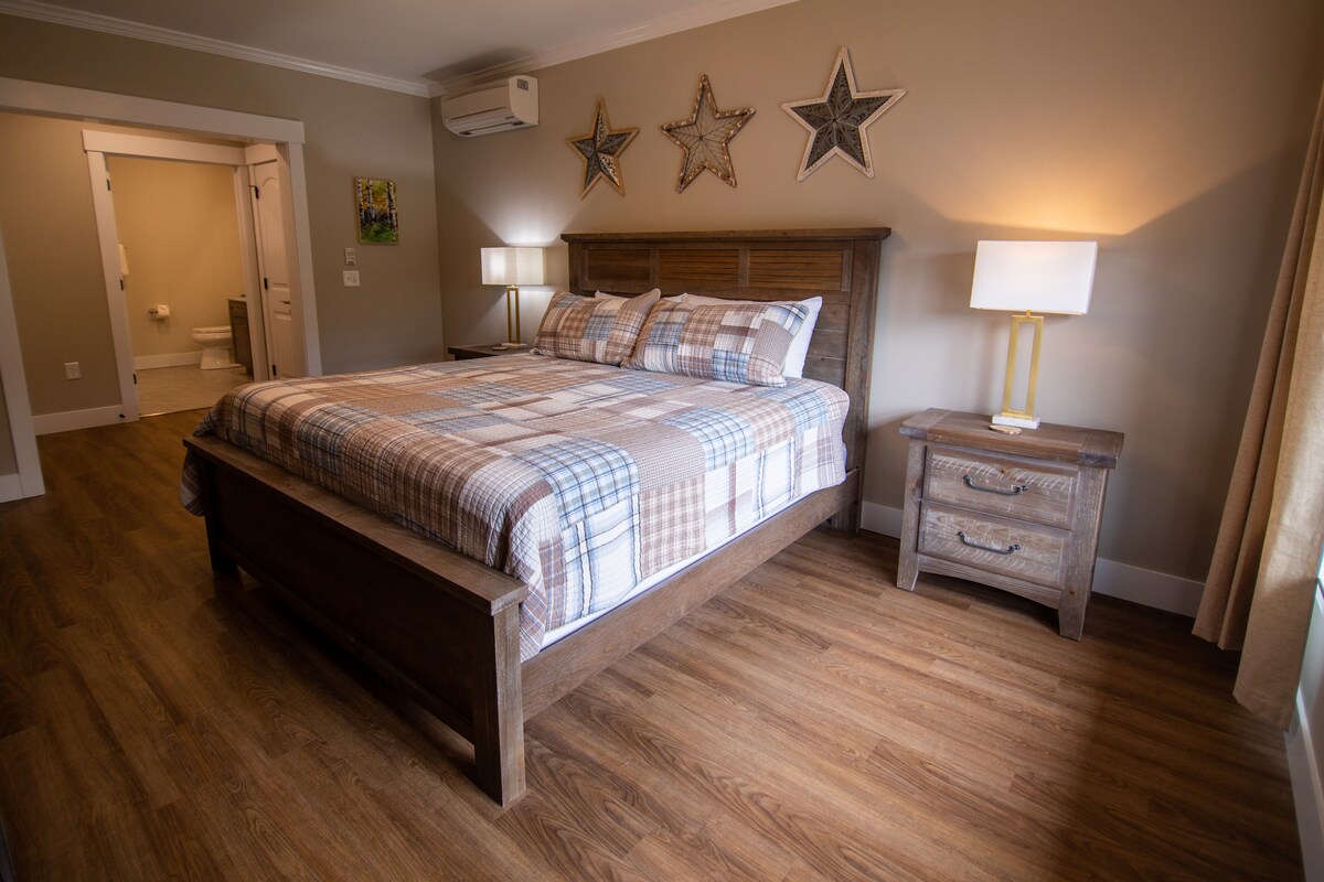 Dormitorio principal con baño privado, armario y TV en el dormitorio.