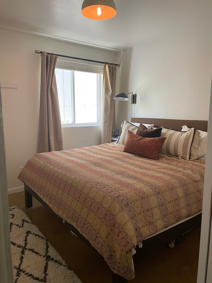 ห้องนอนชั้นล่างพร้อมเตียงขนาดคิงไซส์และม่านบังแสง  