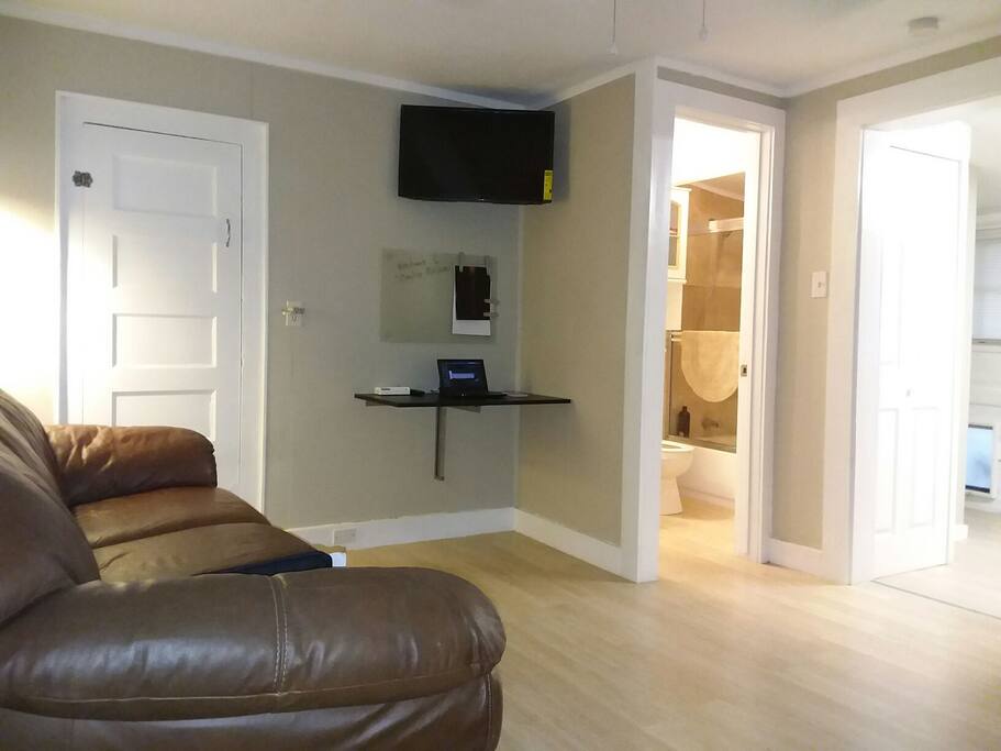 Open, clean Living room with comfortable leather sofa and intelligent Roku TV. Computer friendly work space, with WiFi internet connection.