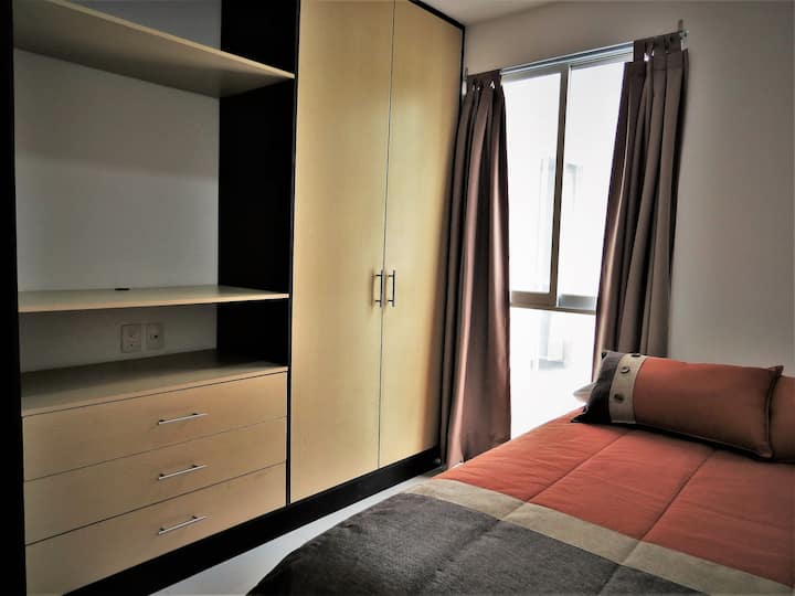 Dormitorio con una cama de matrimonio y armario completo