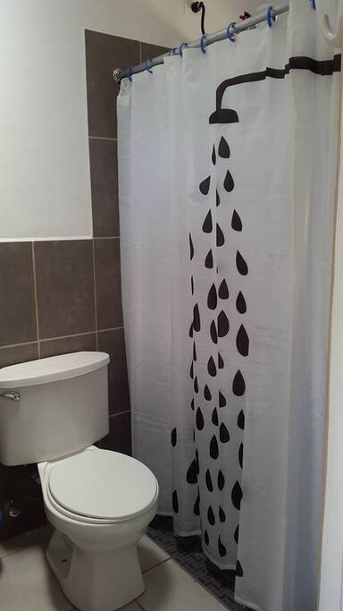 Baño moderno con ducha de agua caliente.
