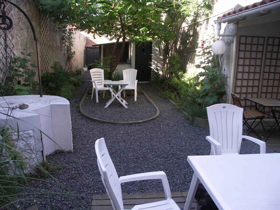 Des roses trémières, des iris, des papyrus... Accès au garage au fond. Le garage donne aussi sur la rue.