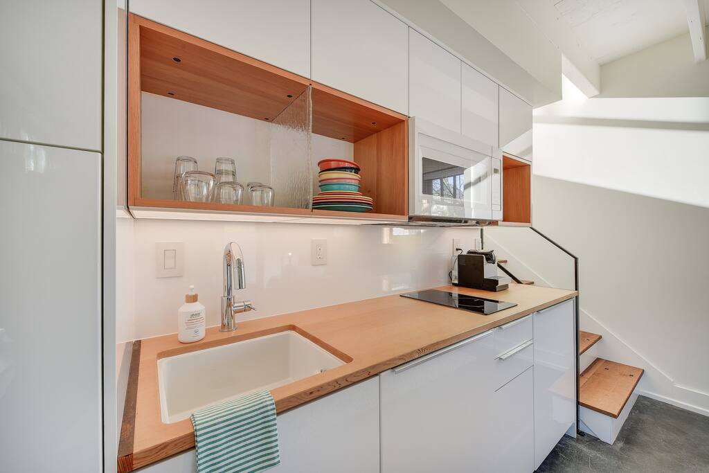 The kitchen has a microwave, stovetop, dishwasher, small fridge, and Nespresso with coffee included.