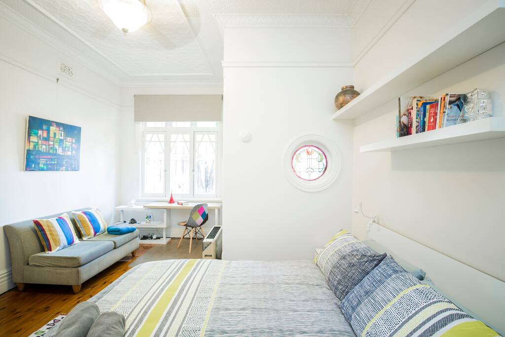 Light-filled front bedroom with work space and seating/reading area