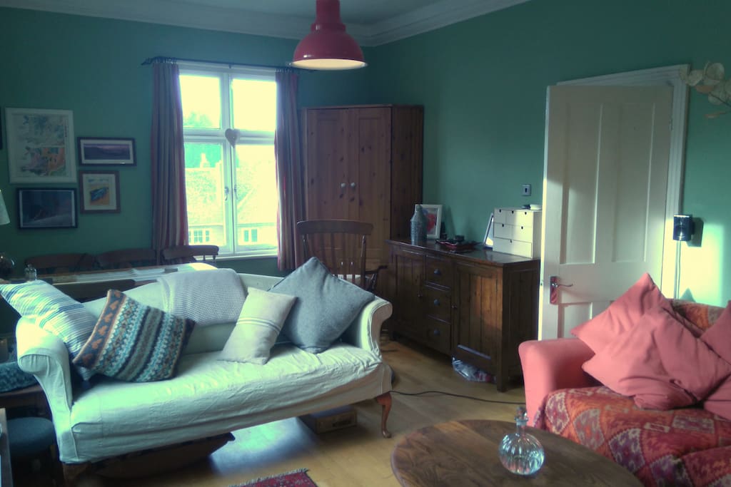 Light and airy Dual aspect sitting room with wooden floor and rugs throughout