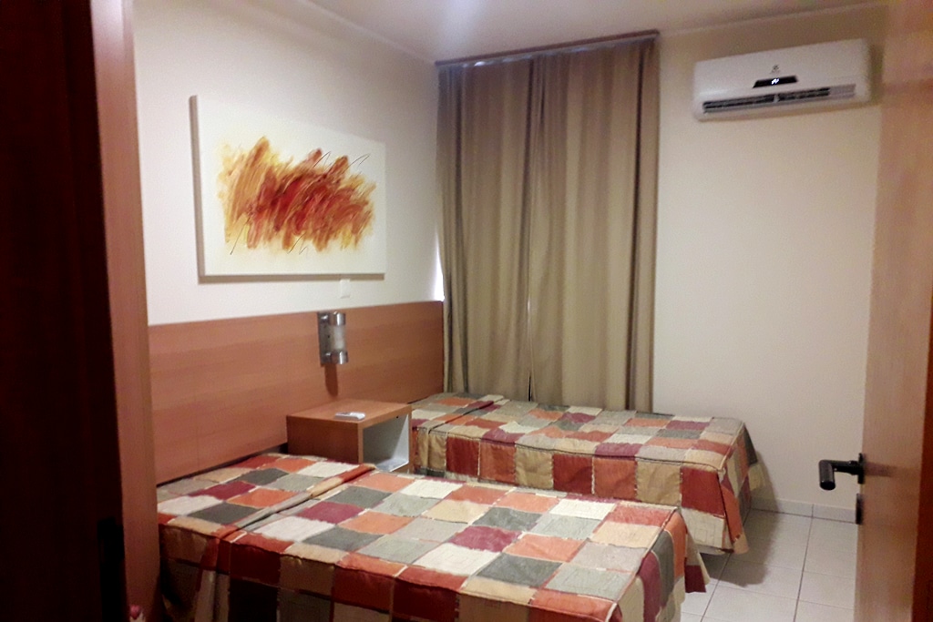 غرفة في الطابق الأول تضم سريرين مزدوجين وخزانة ملابس وتكييف هواء ودخول إلى الحمام.