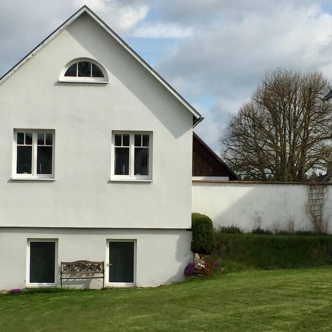 Sitzplatz in der Sonne, darüber Wohnzimmerfenster und Dachluke