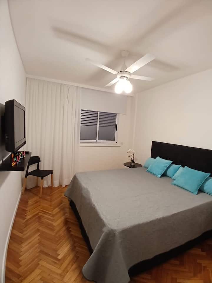 Vista de tv smart y velador en dormitorio formato cama matrimonial