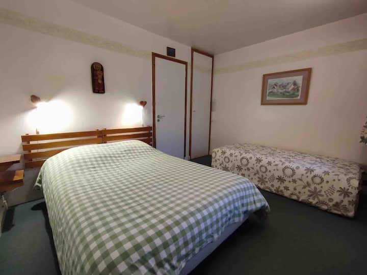 Habitación con cama doble, cama individual y armario con armario de altura