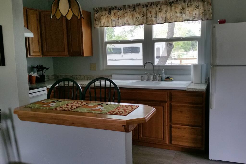 window overlooking farm with eat at bar. stove off to left