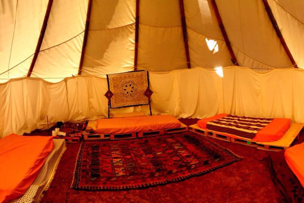Tipi con varias tarimas con colchones para dormir