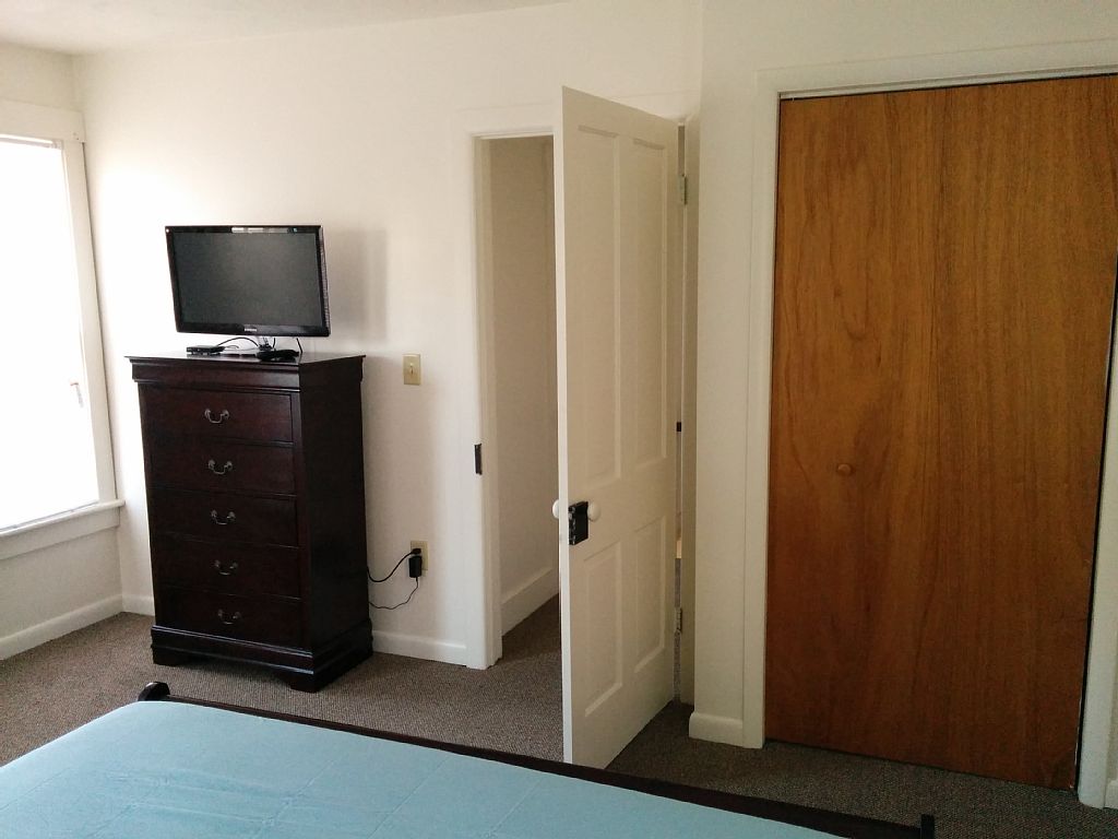Front Bedroom looking at TV, entry door and closet
