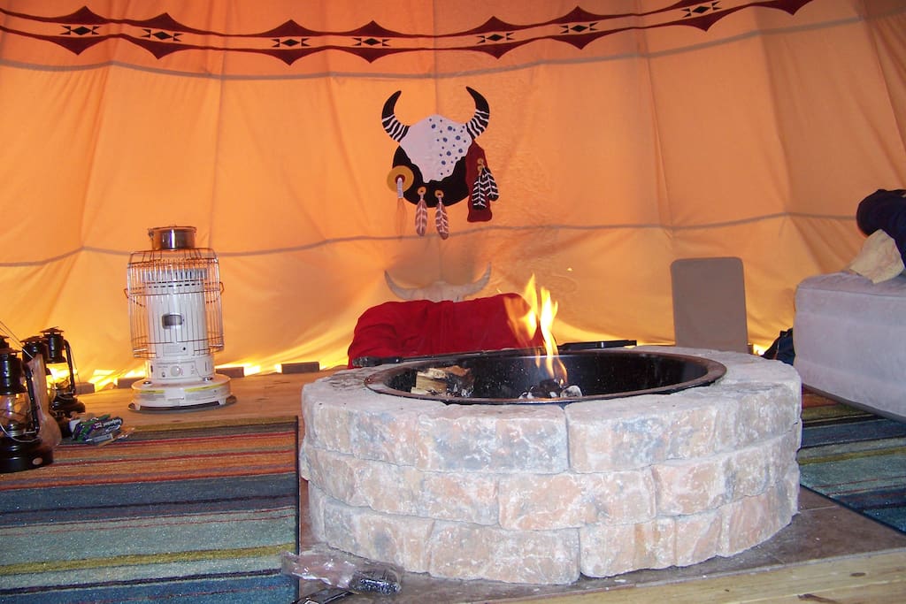 Inside view or the tipi with the firepit and fire. All cooking is done over the fire or outside on your choice of camp stove.