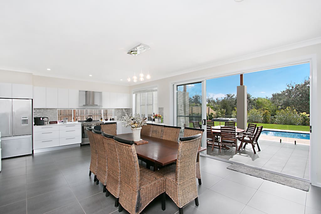 Dining and kitchen area with access to outdoor alfresco area and pool