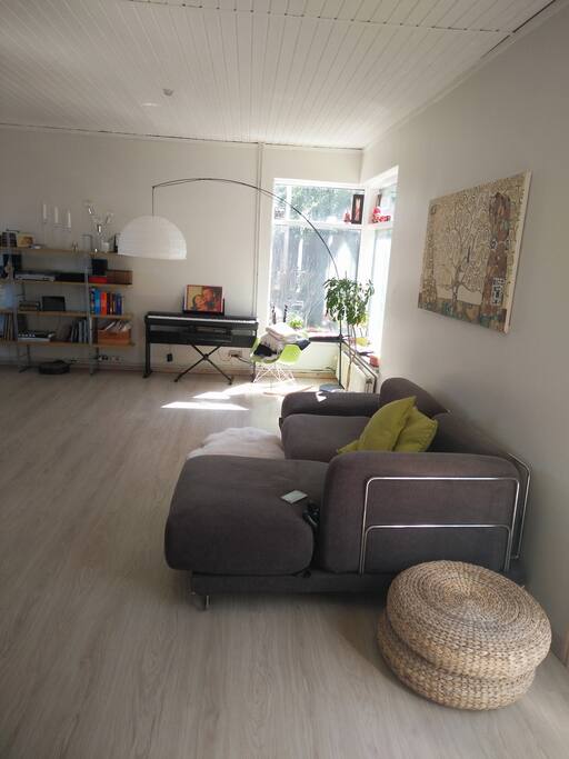 Couch in the living room and the window corner with a piano